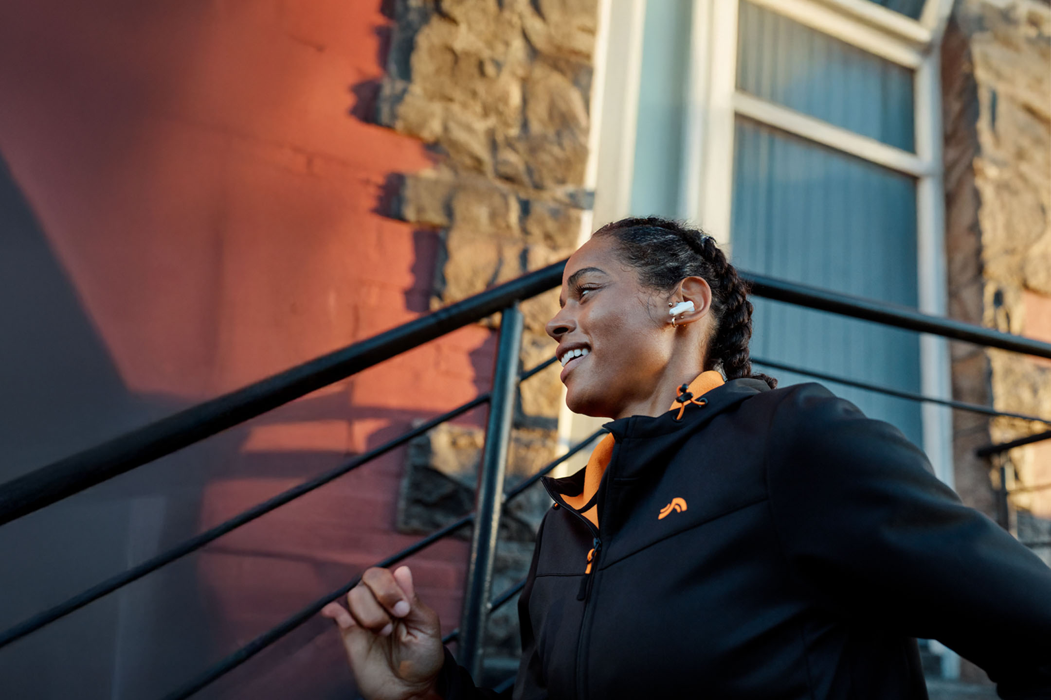 Naine jookseb kõrvaklappidega, seljas jope.